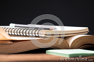 Notebook above the opened book Stock Photo