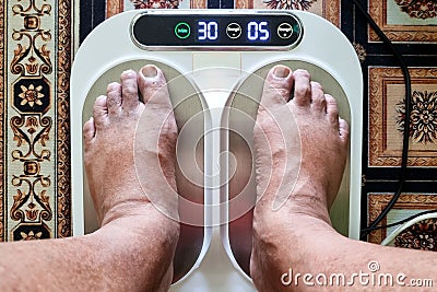 Closeup of person feet receiving magnetic therapy from electricity powered geomagnetic device, promising general well Stock Photo