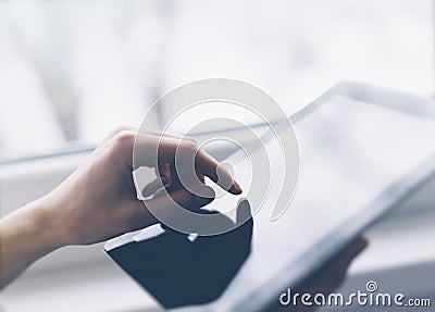 Closeup of a person pointing finger to a computer monitor with a blank screen blue against a background of window horizontal Stock Photo