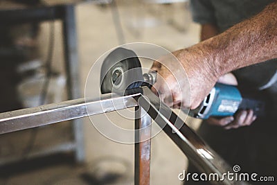 Closeup of a person polishing steel under the lights in a garage Stock Photo