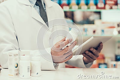 Closeup Pharmacist Holding Pills Bottle and Tablet Stock Photo