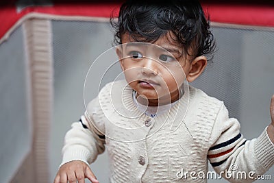 closeup photo of an adorable baby indian boy with worried face Stock Photo