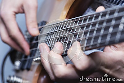 Closeup photo of bass guitar player hands, soft selective focus, live music theme Stock Photo