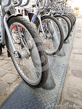 Closeup image of bicycles locked on the bike rental parking at old european town Stock Photo
