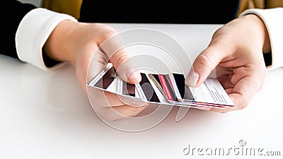 Closeup image of busineswoman sitting behind desk and holding big stack of credit cards Stock Photo