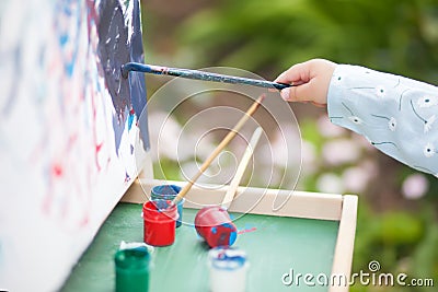 Closeup photo, child painting on easel Stock Photo