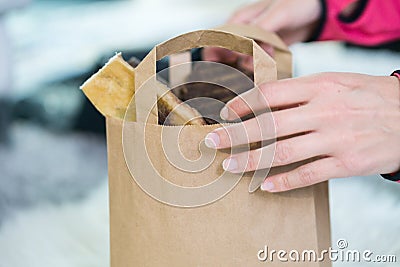 Crop female hand holding paper bag from the store Stock Photo