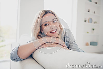 Closeup photo of domestic pretty charming blond lady relaxing sit comfy couch staying home good mood toothy smiling Stock Photo