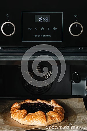 Closeup photo of galette with black currant baking in a oven Stock Photo