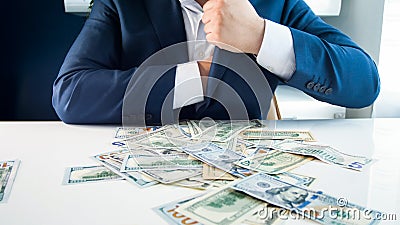 Closeup photo of greedy businessman filling his pockets with money Stock Photo