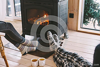 Closeup photo of human feet in warm woolen socks over fire place Stock Photo