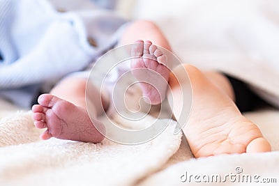 Closeup photo of little legs of newborn and older baby Stock Photo