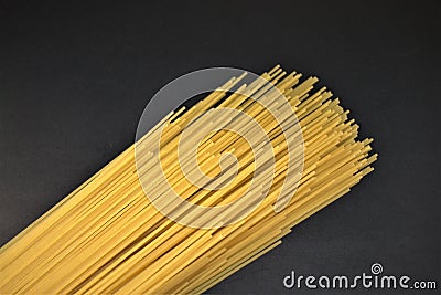 Closeup photo of uncooked spagetti pasta isolated on black background. Stock Photo