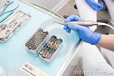 Closeup picture of dental instruments: drill and needle for root canal treatment and pulpitis in hand at the dentist Stock Photo