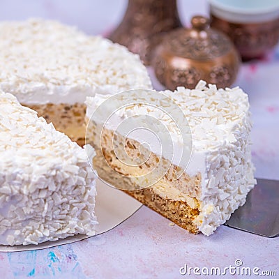 Closeup of the piece of coconut cheesecake covered with grated coconut with a blurry background Stock Photo