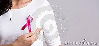 Closeup of pink badge ribbon on woman chest to support breast cancer cause. Healthcare, medicine and breast cancer awareness Stock Photo