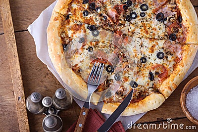 Closeup pizza with sausage, ham, olives, mozzarella Stock Photo