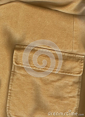 Closeup pocket. Raw sienna or ocher color cotton shirt. English style. Solid fabric texture. Casual style. Empty space for text. Stock Photo