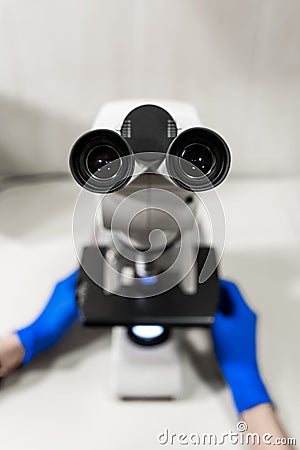 Close up point of view of laboratory assistant looking through microscope lens Stock Photo