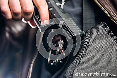 Closeup of police officer taking out handgun from holster at nig Stock Photo