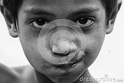 Closeup of a poor staring hungry orphan boy in a refugee camp with sad expression. Editorial Stock Photo