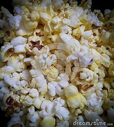 Closeup of popcorns with melted butter isolated from black round vignettes, food photography, snacks background Stock Photo