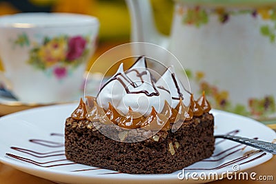 Closeup of a portion of delicious brownie with manjar and meringue on a white plate Stock Photo