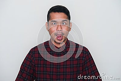 Closeup portrait of adult Asian man showing funny ugly face Stock Photo
