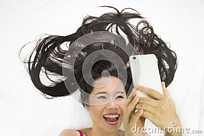 Closeup portrait of asian women lying on ground with black long hair. acting wow , and plying phone Stock Photo