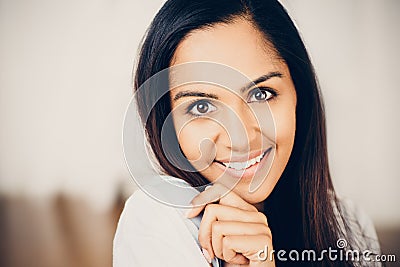 Closeup portrait of attractive indian young woman smiling at home Stock Photo