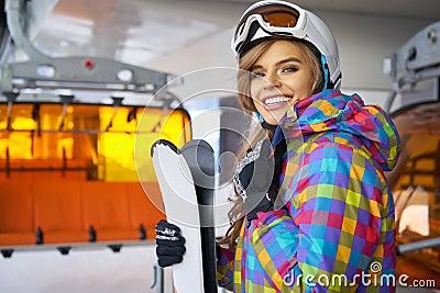 Closeup portrait of beautiful skier girl wearing mask and holding ski, enjoying winter holidays Stock Photo