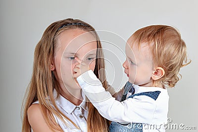 Closeup portrait of a brother and sister. A girl is frowning, and a child is trying to cheer her up. true emotions. Stock Photo