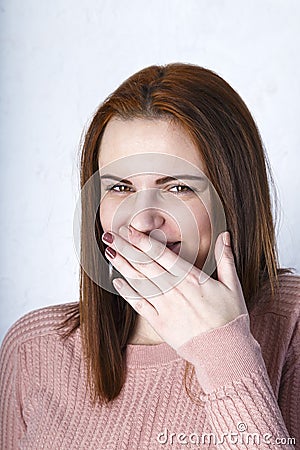 Closeup portrait cheerful girl with beautiful face and attractive amile. Smiling shy woman covering mouth her face with a hand Stock Photo