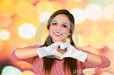 Closeup portrait of female clown mime making a heart with hands Stock Photo