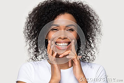 Closeup portrait happy african woman cleaning teeth with dental floss Stock Photo