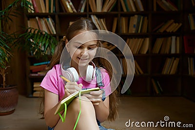 Closeup portrait of little smart schoolgirl writing in her diary Stock Photo