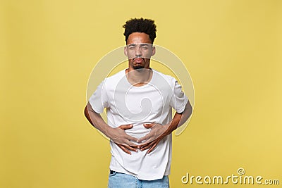 Closeup portrait of miserable, upset, young man, doubling over in stomach pain, looking very sick unwell, isolated on Stock Photo