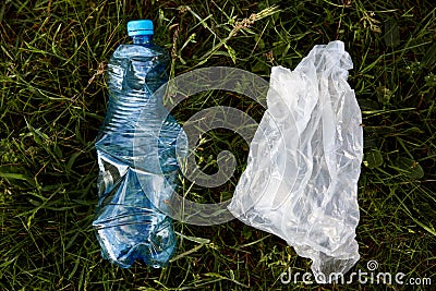 Closeup portrait of plastic bag and plastic used bottle, rubbish in meadow, trash in field, ecological problems, waste, Stock Photo