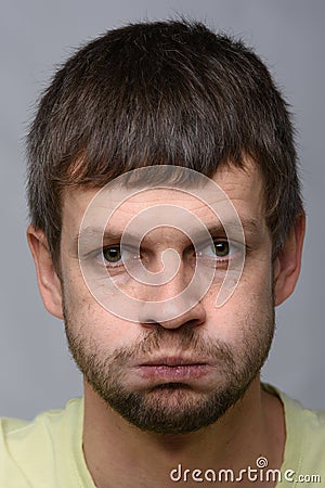 Closeup portrait of a resentful man of European appearance who pouted his cheeks Stock Photo
