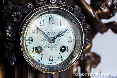 A closeup portrait of the retro clock face of an old vintage clock made of wood and metal with beautiful clock hands and numbers Stock Photo