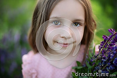 Closeup portrait of a romantic charming little girl with long hair. Childhood concept. Smiling child girl with big eyes looking in Stock Photo