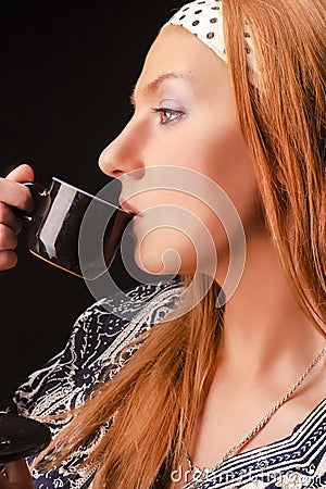 Closeup Portrait of Tranquil Blond Girl With Headband Posing With Coffee Cup Over Black Background Stock Photo
