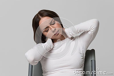 Female massages painful neck pain and back, isolated. Cervical arthritis, osteochondrosis Stock Photo