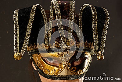 Closeup portrait of woman isolated over dark background wall wearing carnival masquerade mask Stock Photo