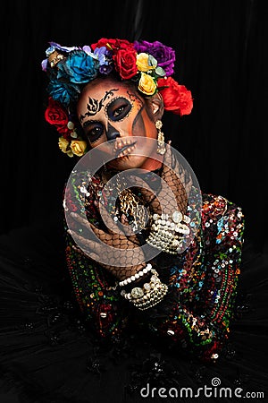 Closeup portrait of woman with a sugar skull makeup dressed with flower crown Stock Photo