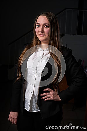 Closeup portrait of a young business woman, happy, cheerful, handsome businessman is standing in a modern office in a white blouse Stock Photo