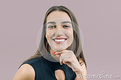 Closeup portrait of young smiling woman, caucasian female`s face on beige pink pastel background Stock Photo