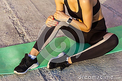 Closeup portrait of young sporty woman in black sportwear sitting on mat with a strong hurt problem with knee, spasm painful. Stock Photo