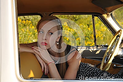Closeup portrait of young woman inside old-fashioned car Stock Photo