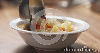 Closeup pouring cauliflower soup into bowl on wood table Stock Photo